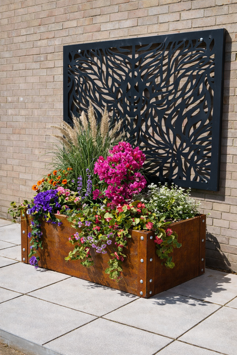 Decorative metal wall panel with floral planter below on a brick wall background