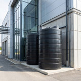 Two large 25000 litre cylindrical tanks outside a modern building.
