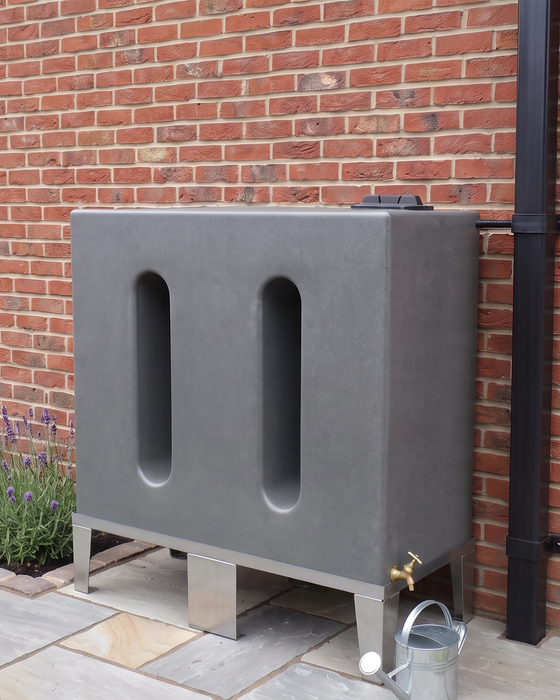 water butt mounted on a metal frame against a red brick wall outdoors.