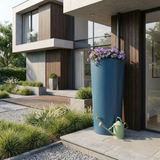 Blue rainwater harvesting tank with flowers in front of a modern house