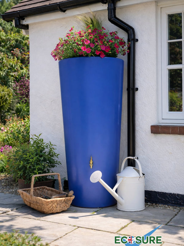 Blue rainwater harvesting tank with flowers and a watering can on a house exterior.