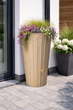 Tall cylindrical water butt planter with decorative flowers on a patio