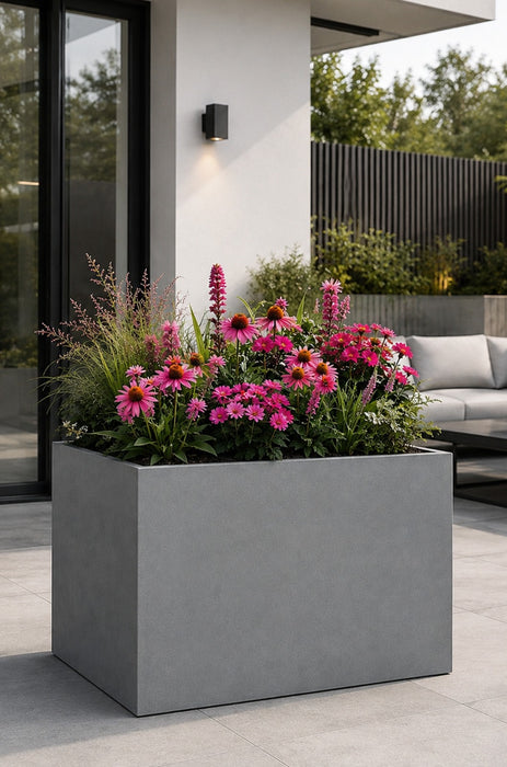 Galvanised planter with pink flowers on a patio