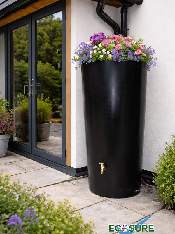 Black rainwater harvesting tank with flowers on top in a garden setting, featuring the Ecosure brand.