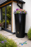 Black rainwater harvesting tank with flowers on top in a garden setting, featuring the Ecosure brand.